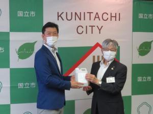 記念撮影を行うFSX株式会社の藤波代表取締役社長(左)と永見市長(右)。