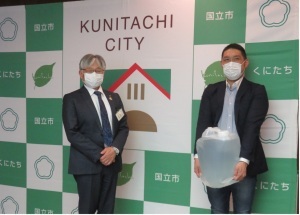 寄贈していただいた製品を手に記念撮影を行う田中様(右)と永見市長(左)。
